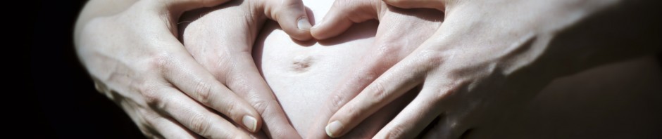 4 hands on belly of pregnant woman